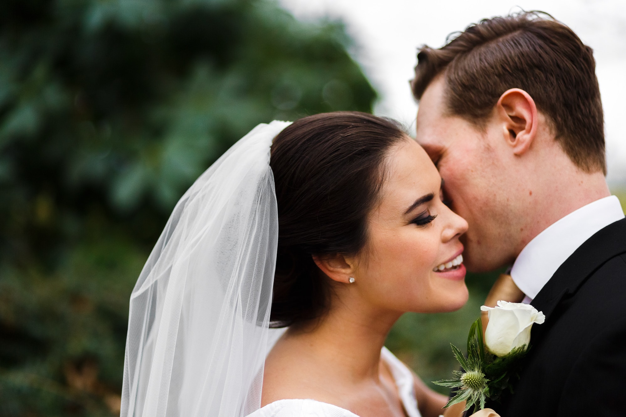 close up picture of groom whispering in brides ear