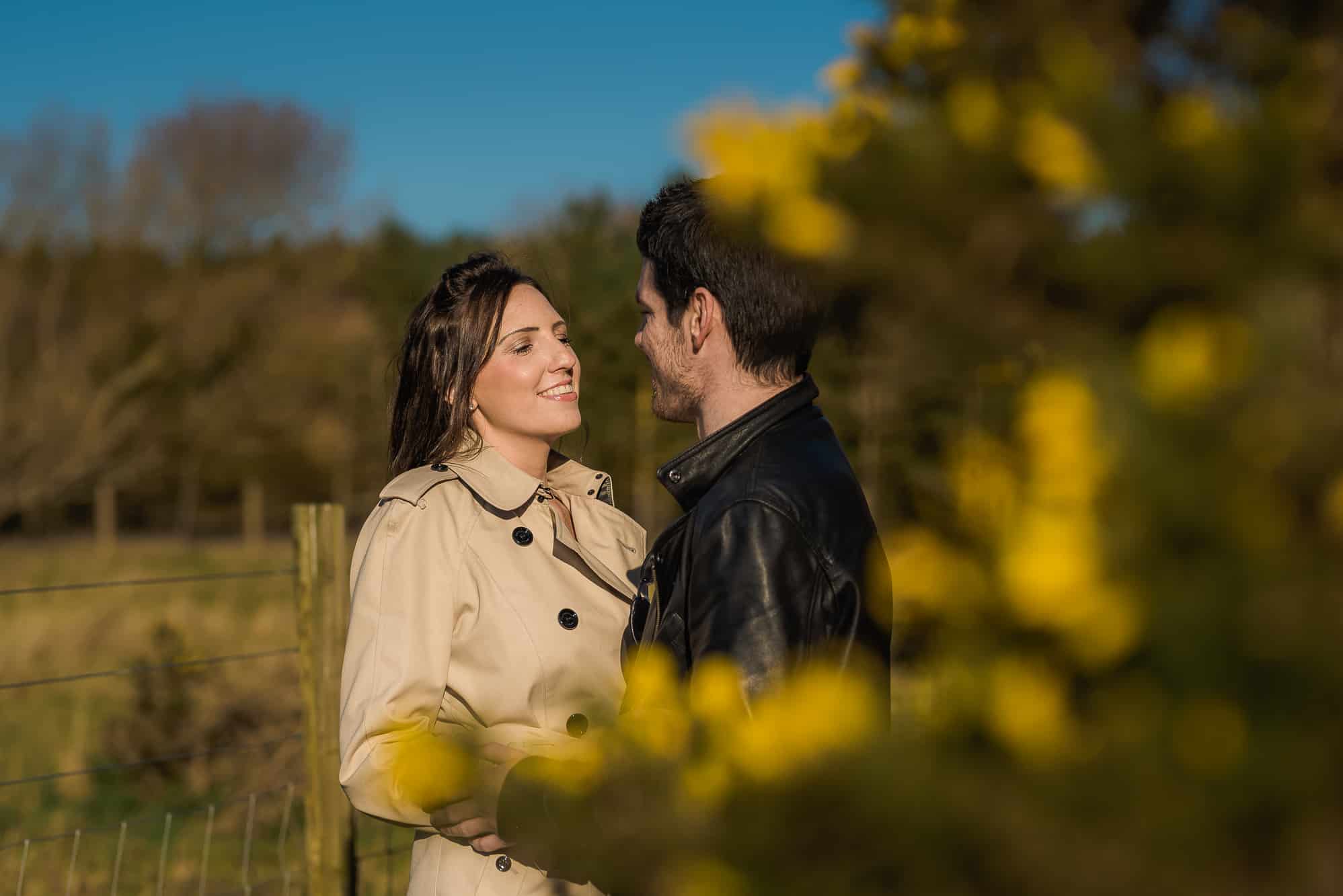 couple kissing near a yellow flower