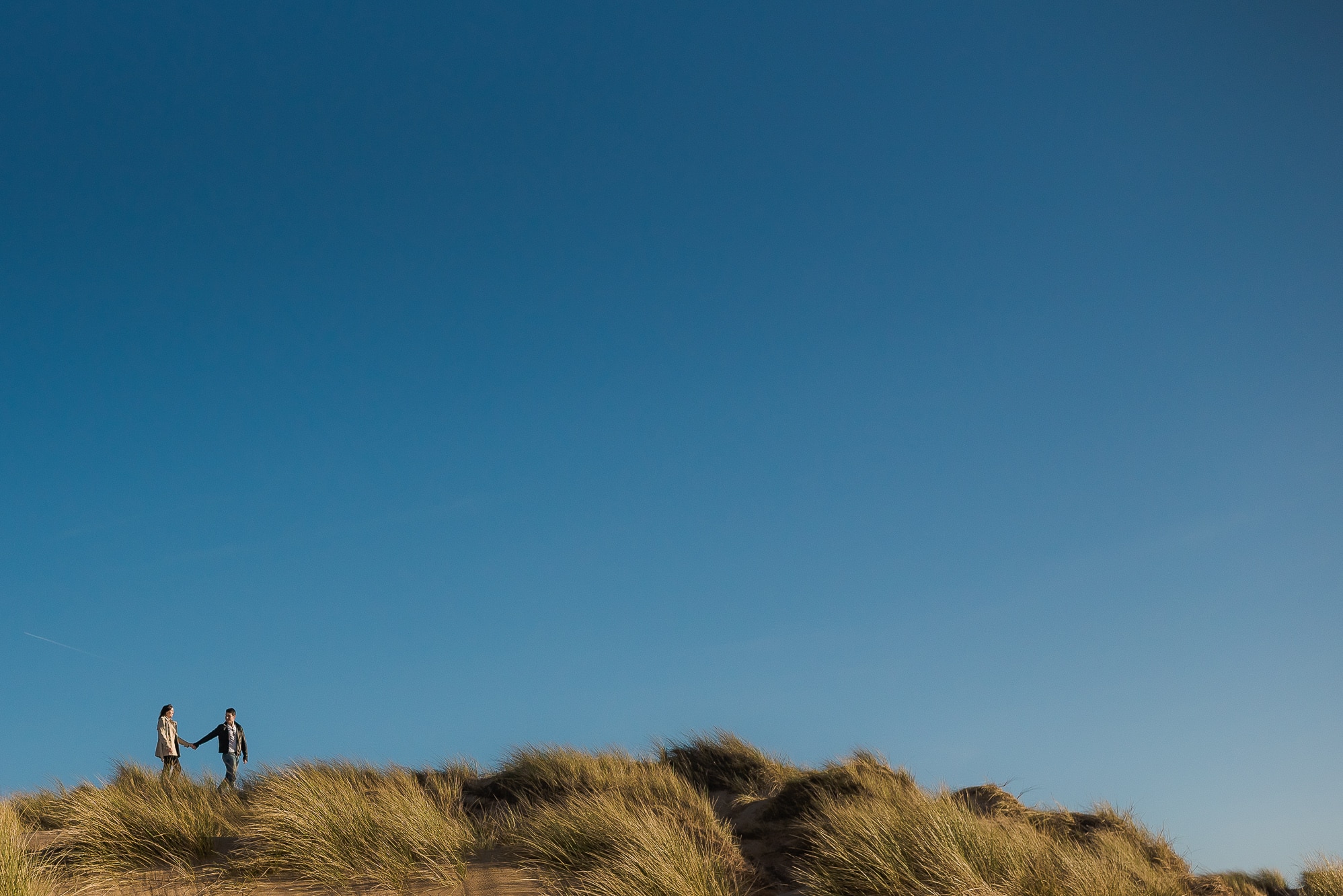 Formby Woods Engagement Shoot | Danielle & Peter 12 Couple walking through sand dunes in the sun