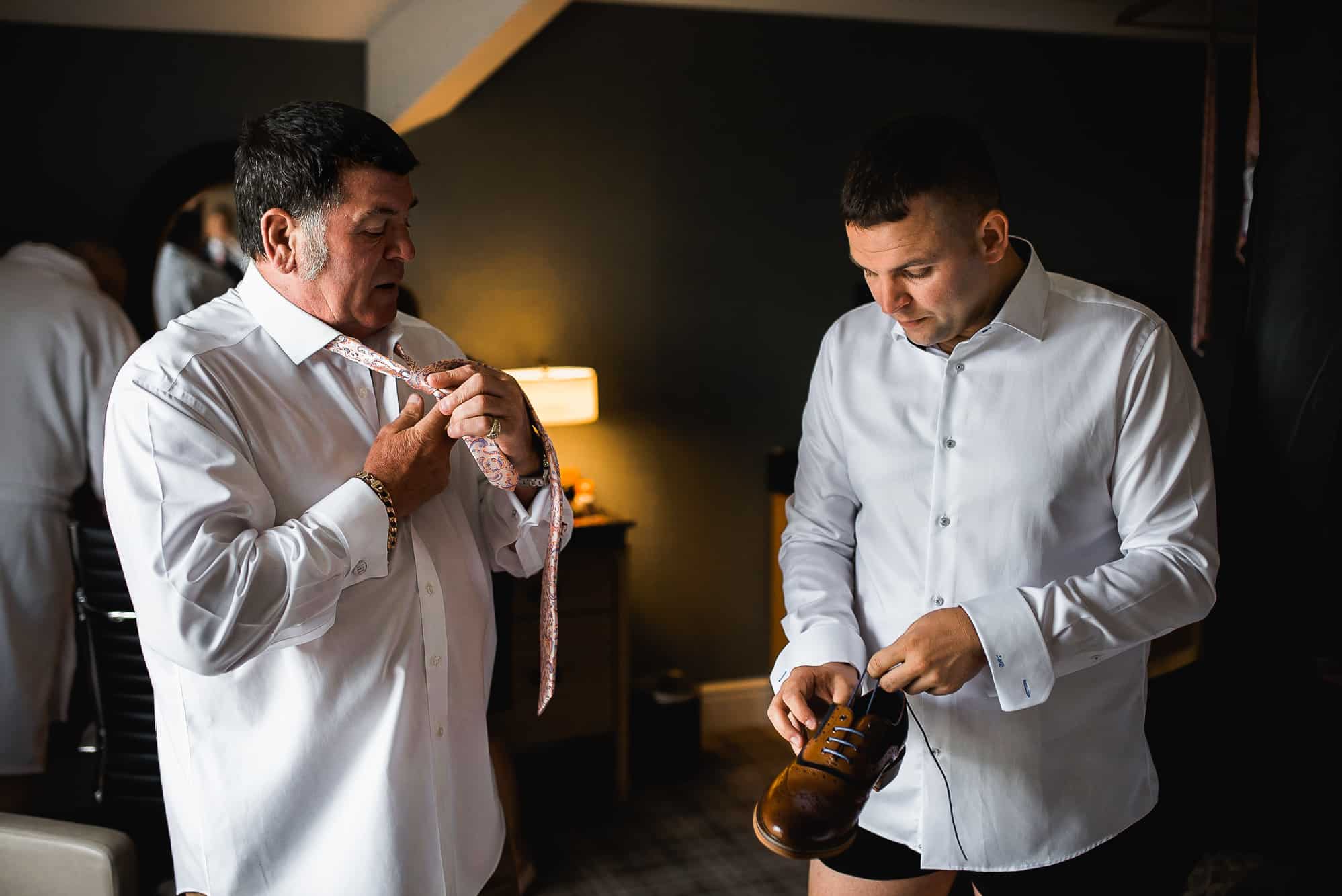 Groom getting his shoes ready