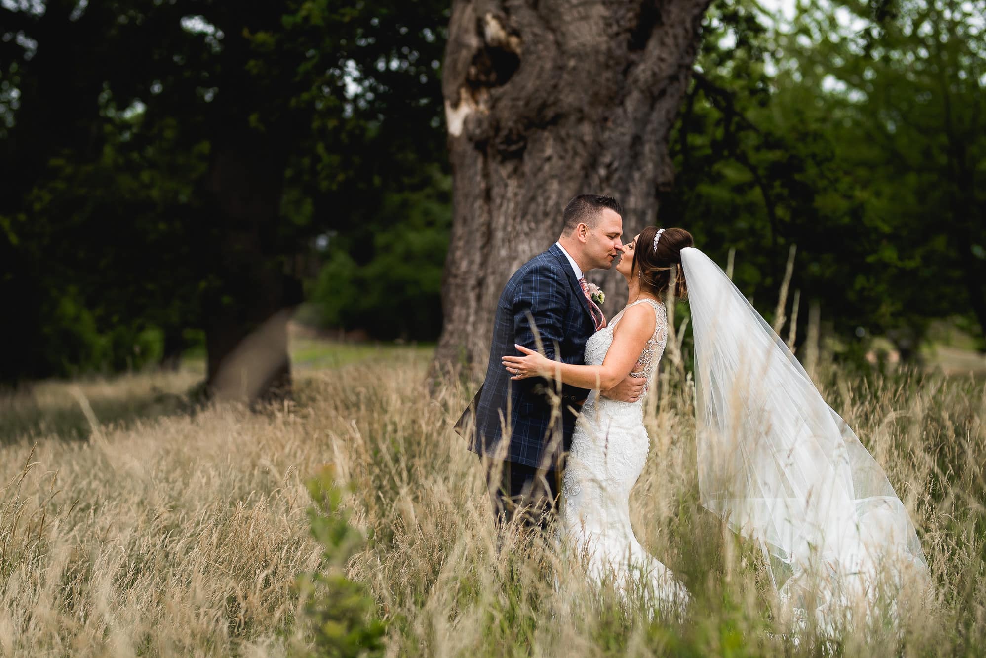 Bride and groom kissing in the field