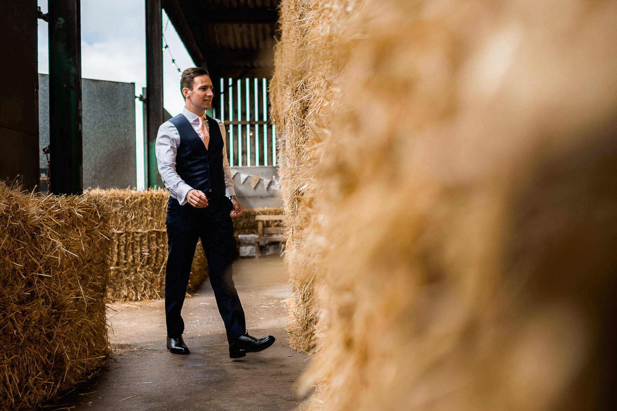 best man walking past some hay