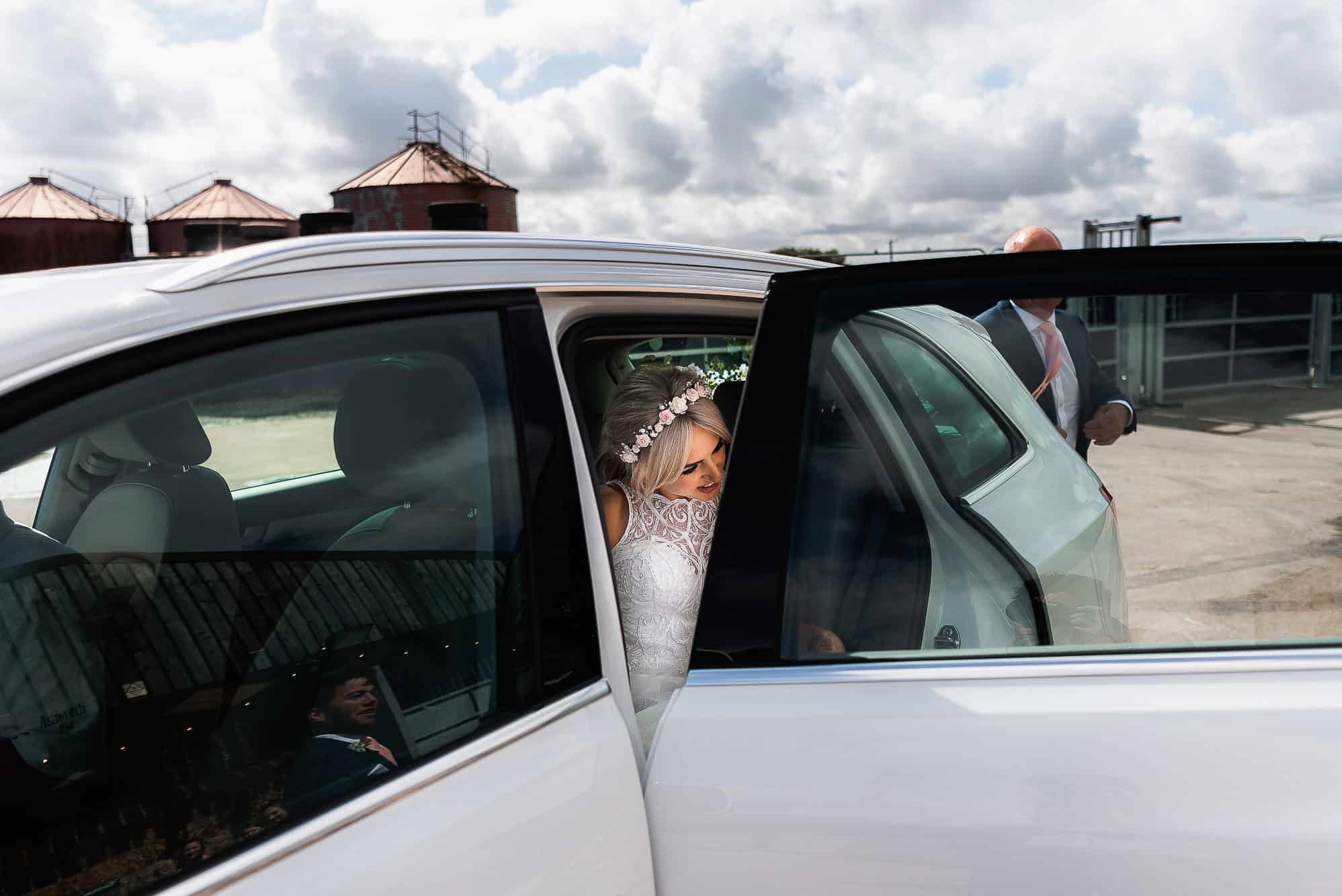 Bride getting out of car at the farm