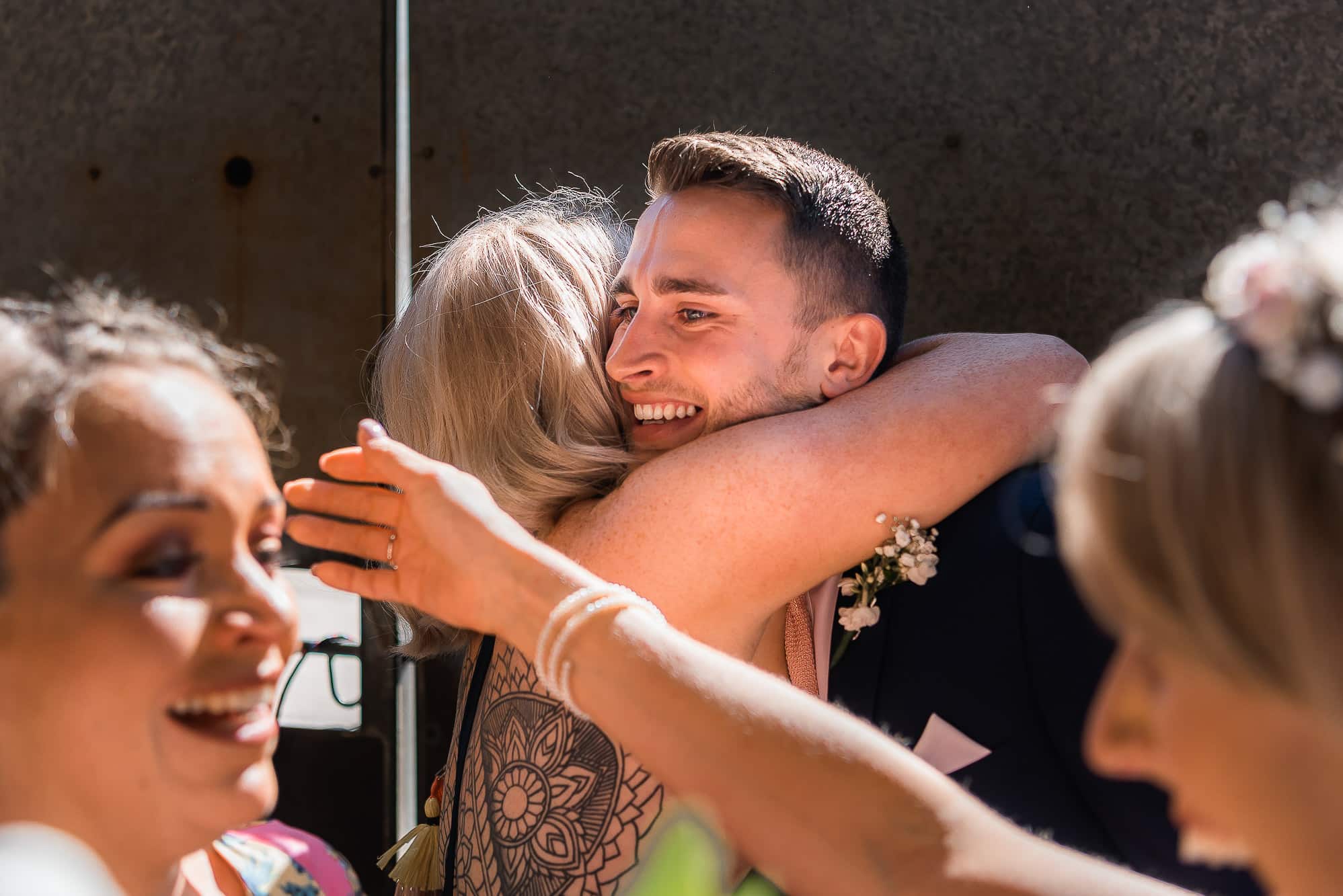 Groom hugging friends