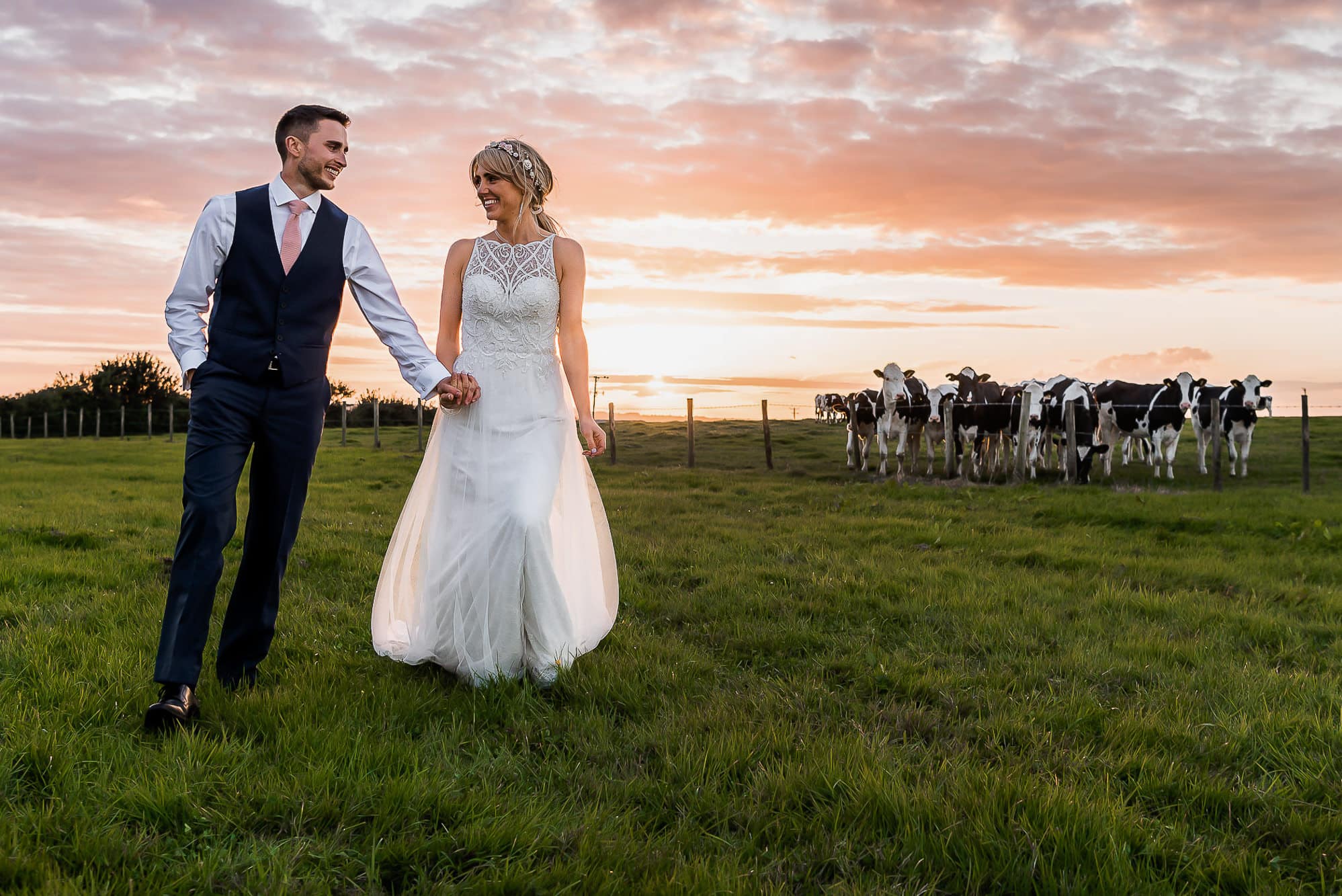 bride and groom walking in sunset