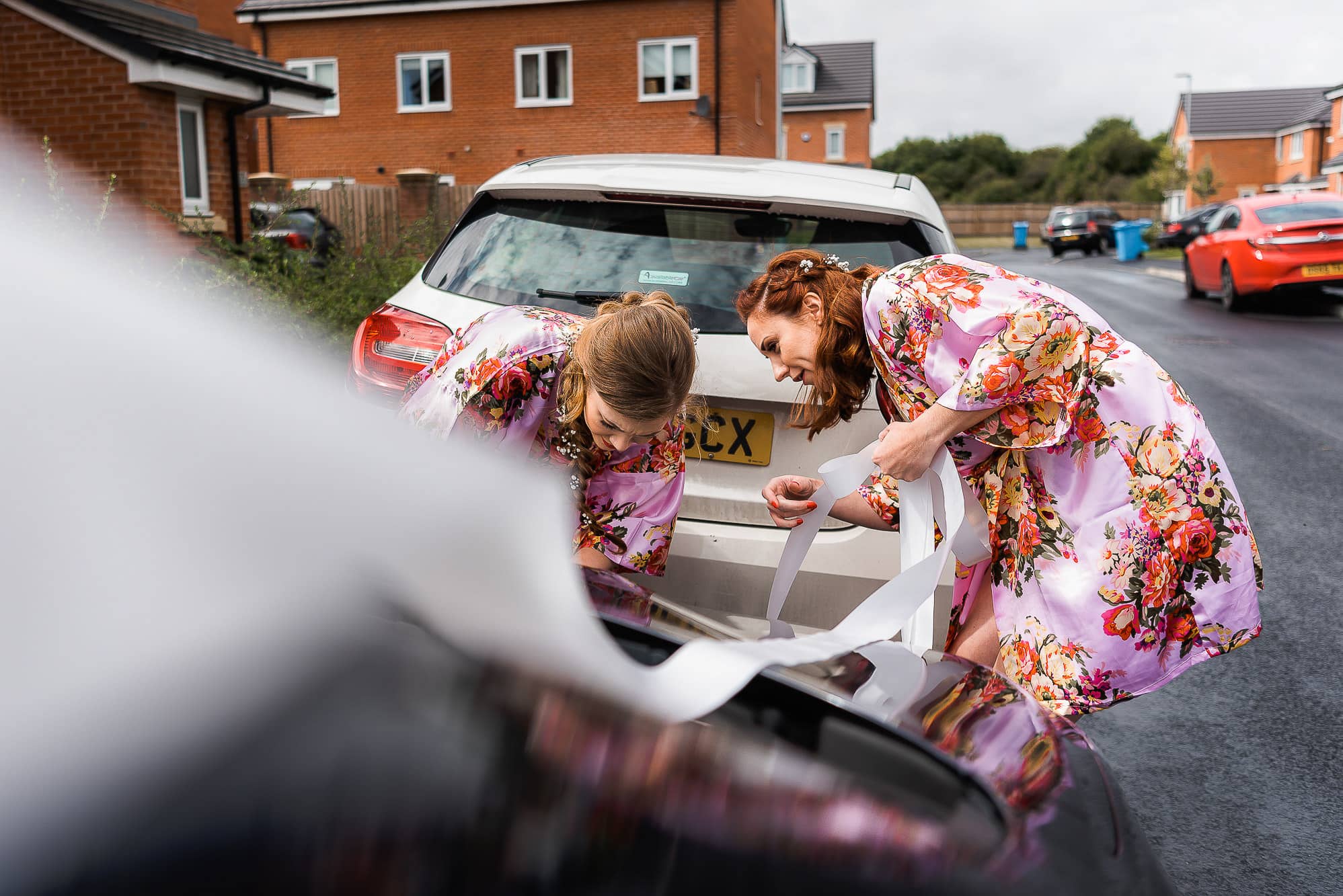 bridesmaids working on the ribbon for car
