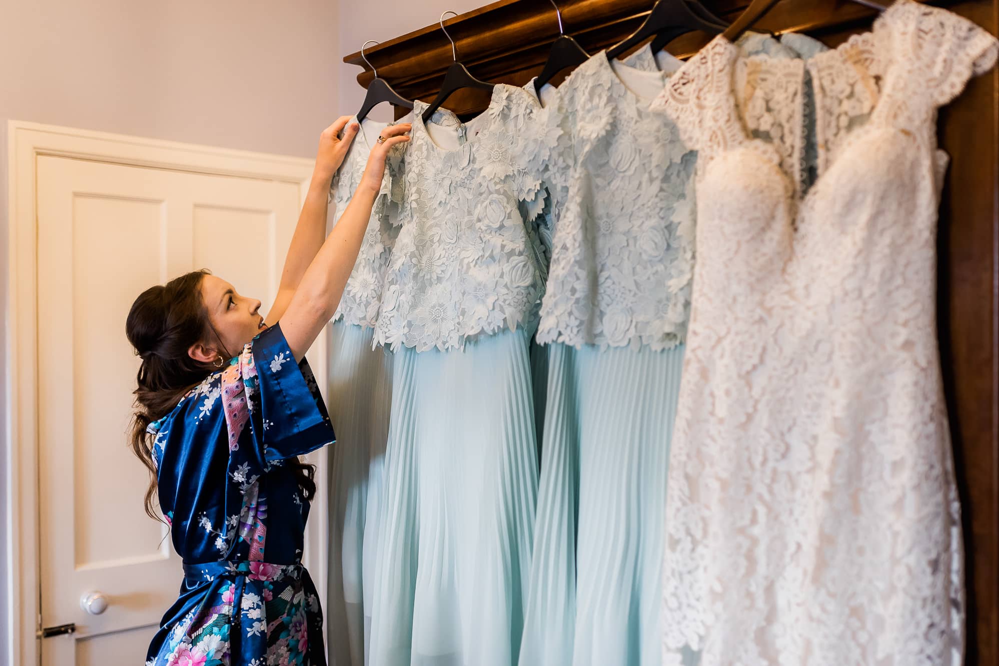 Bridesmaid reaching for dress