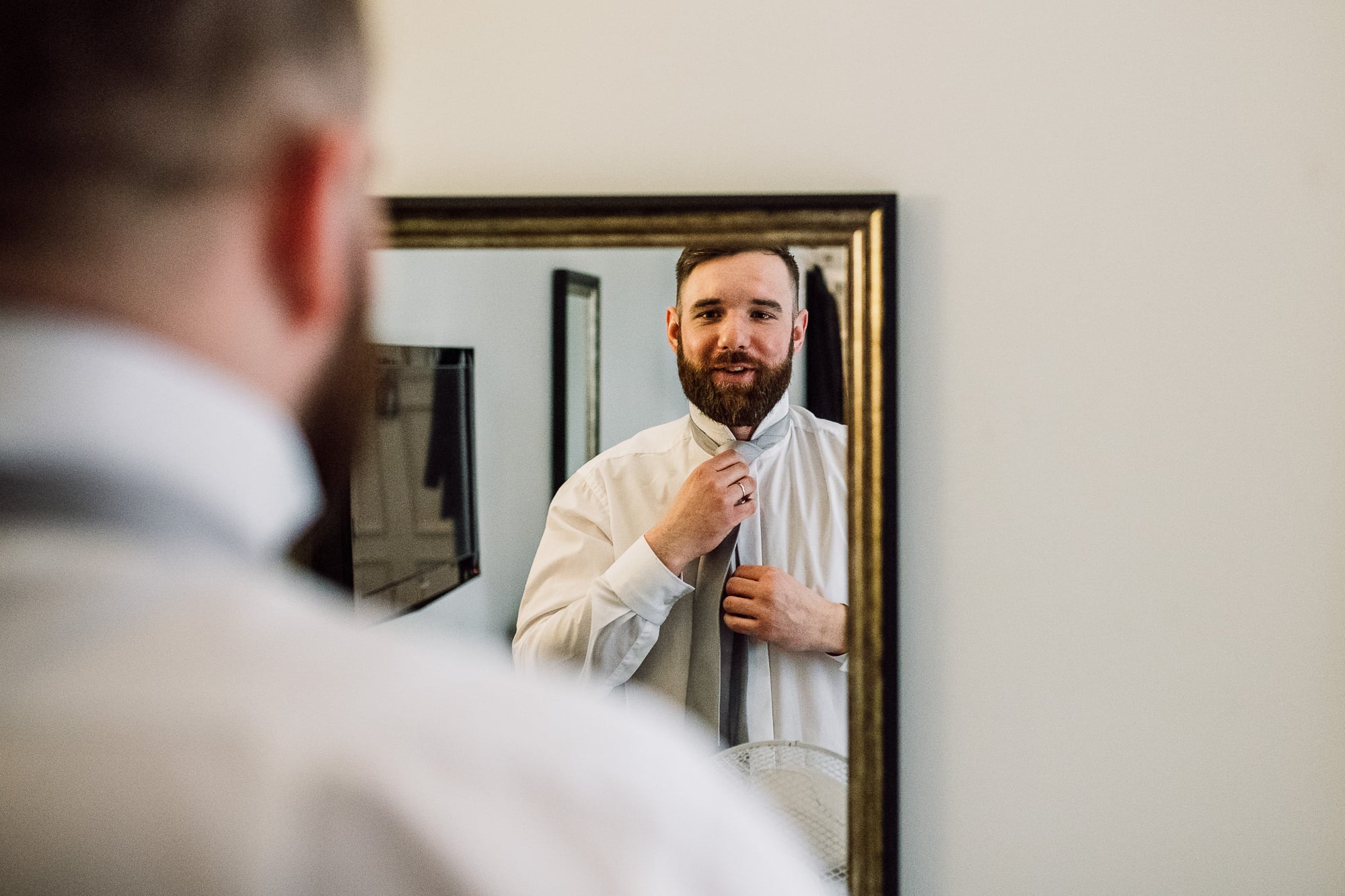 Crabwall Manor Wedding Photography | Mark & Beth 6 Usher gets ready whilst looking in the mirror at Crabwall Manor