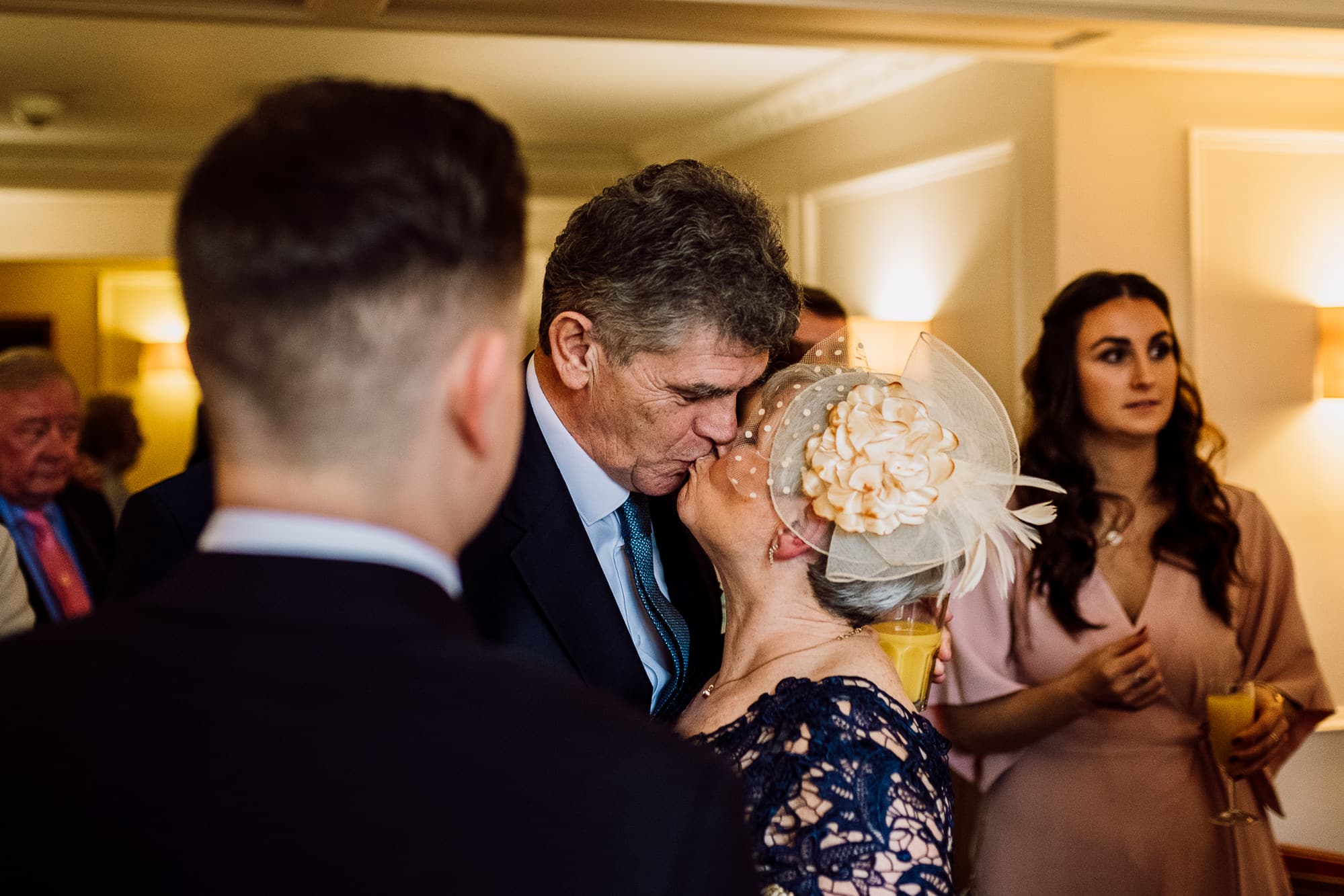 Crabwall Manor Wedding Photography | Mark & Beth 16 The grooms parents kiss during reception drinks