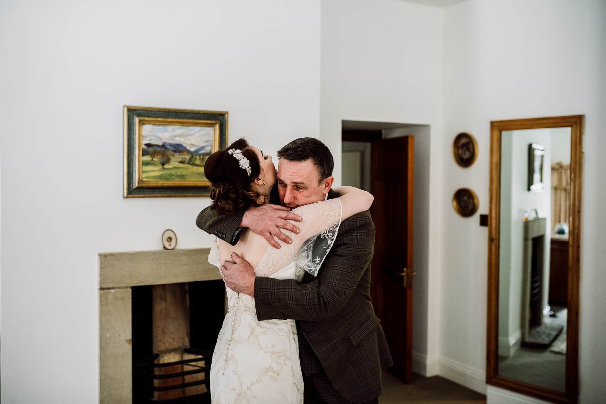 Father of the bride and the bride hug before the service