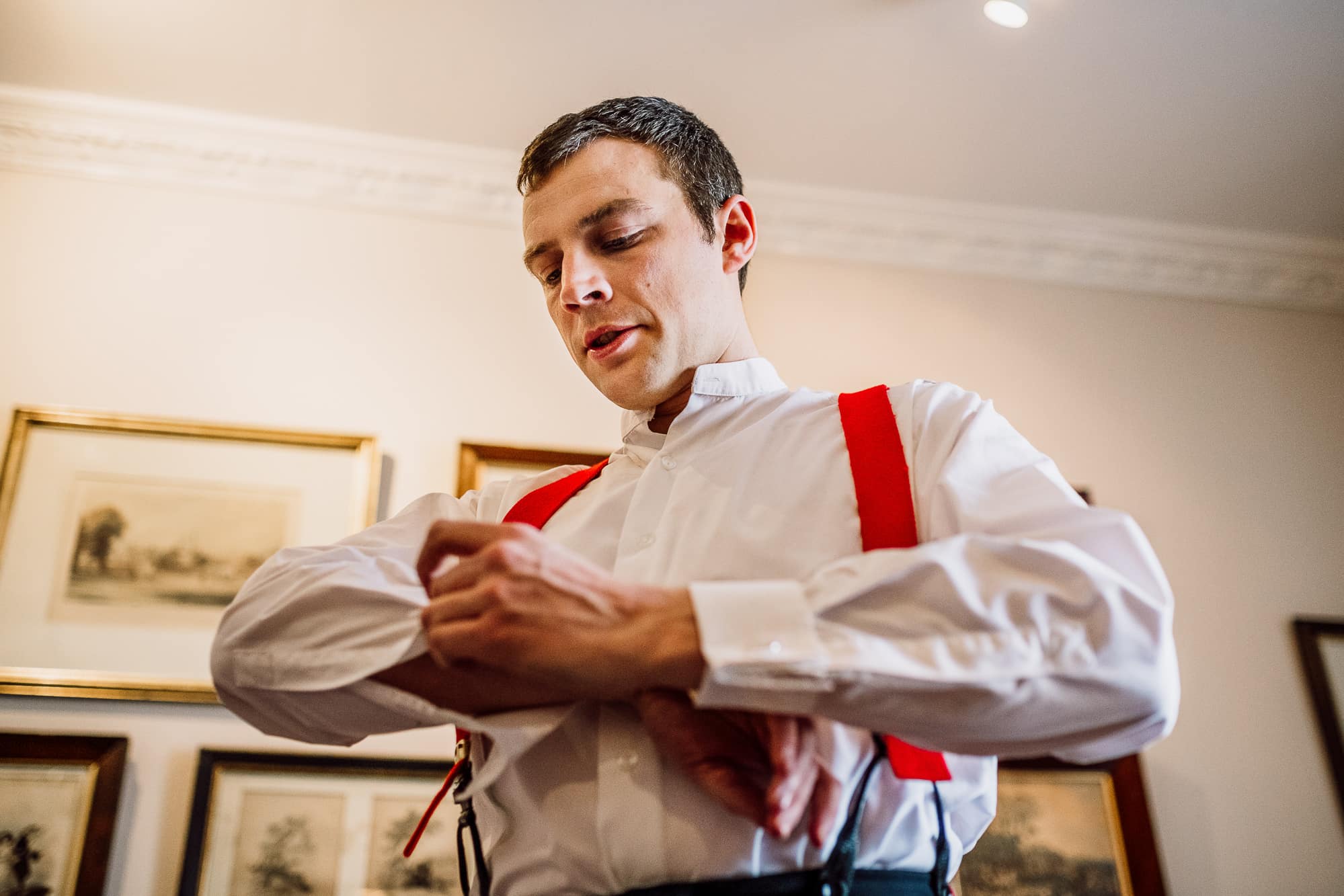 The groom getting dressed into his army uniform at the Inn at Whitewell