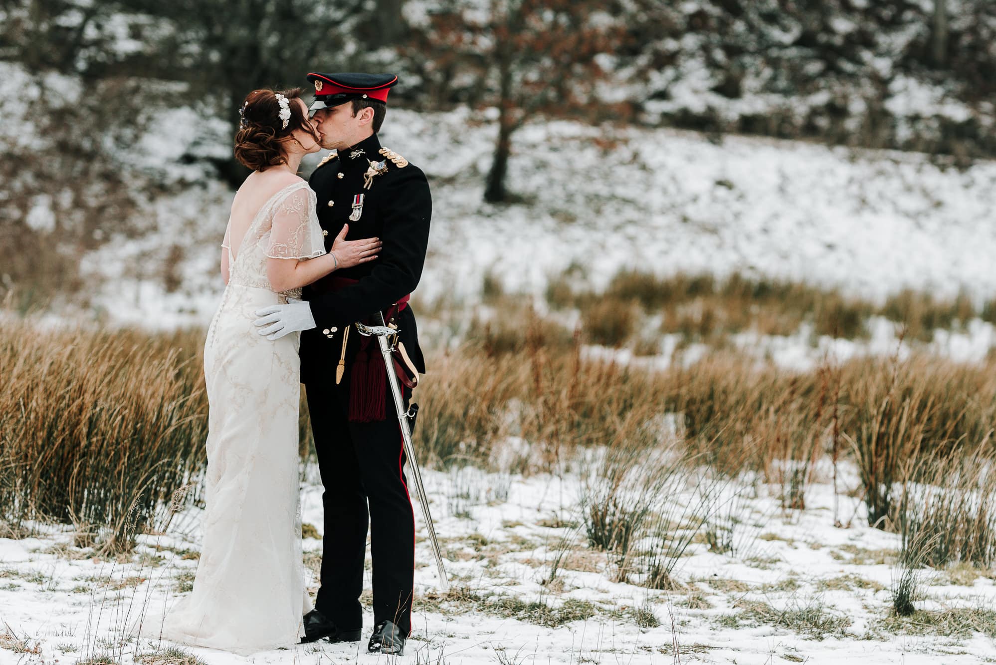 The newly weds kissing in the snow