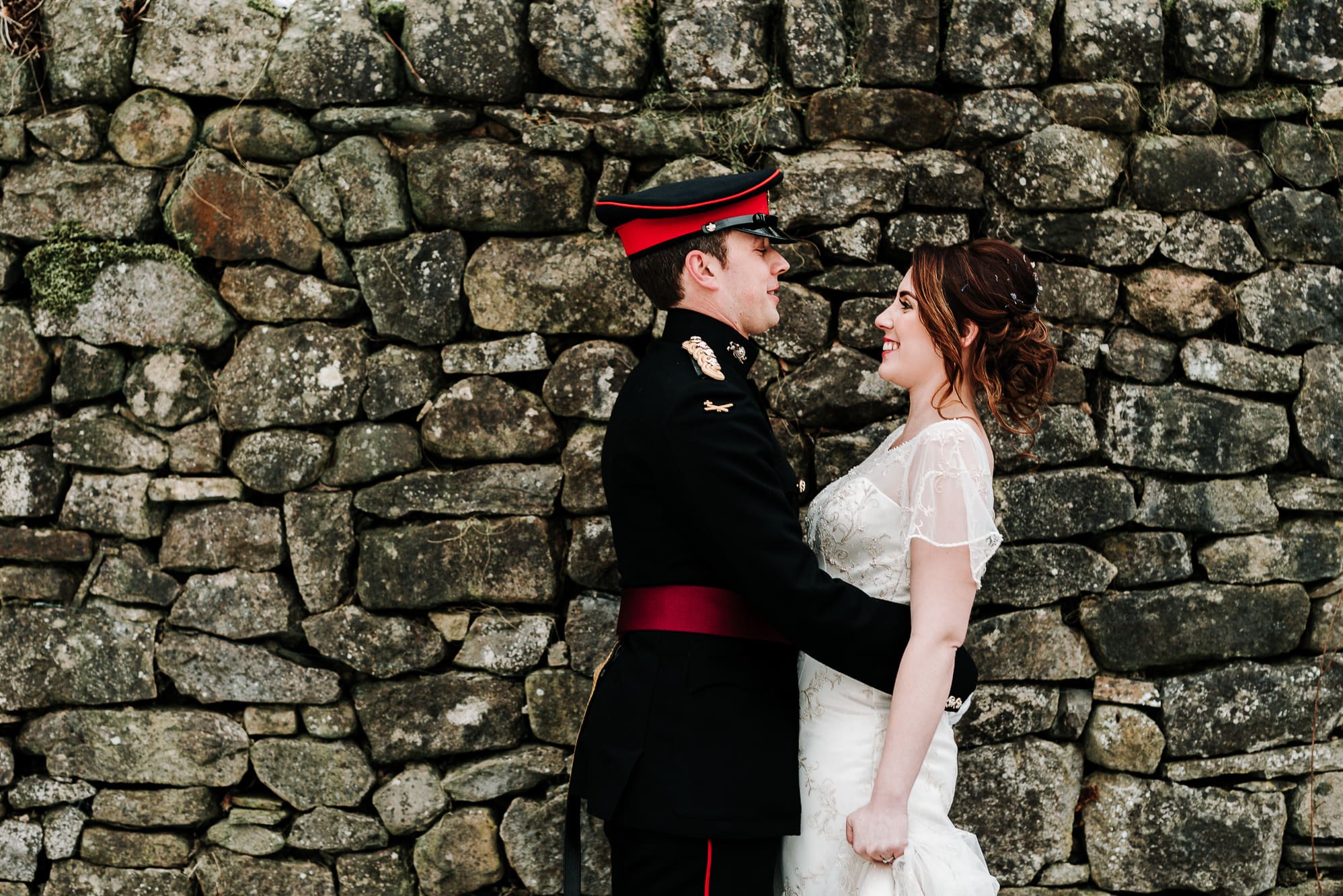 Couple hugging against a wall at the inn at whitewell