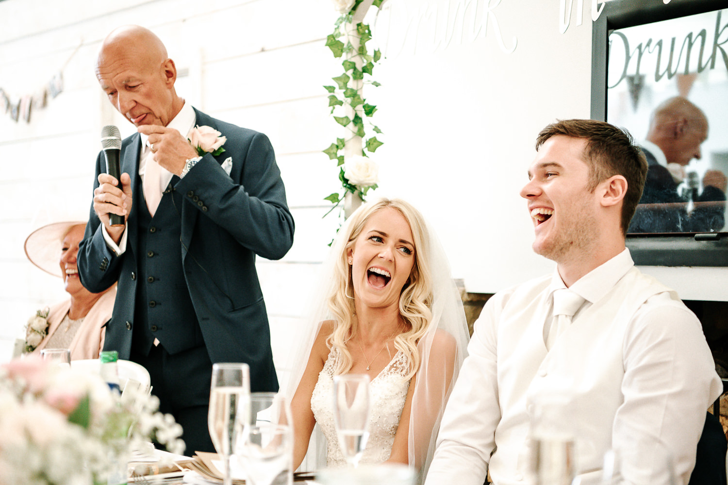 Bride laughing during her dads speech