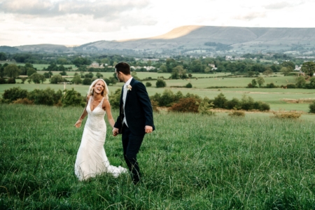 Bride and groom smiling in the field