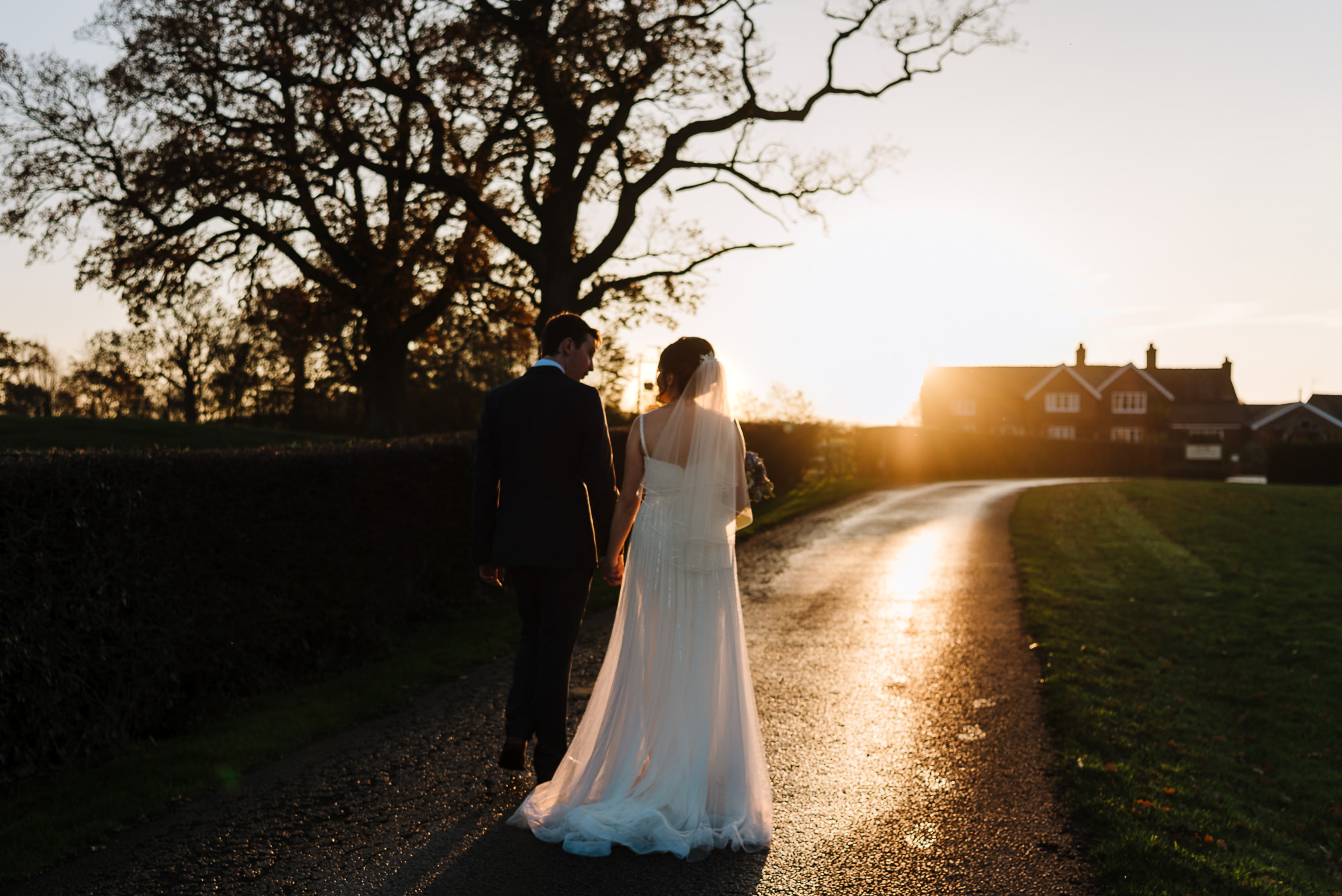 Couple walking in sunset towards Sandhole Oak Barn