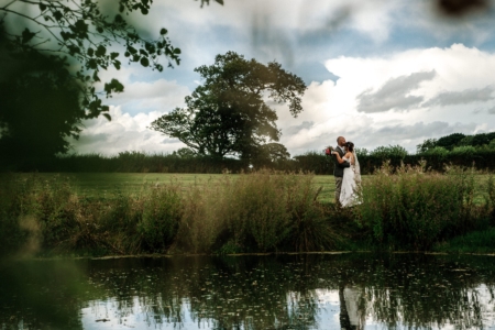 Bride and groom over lake
