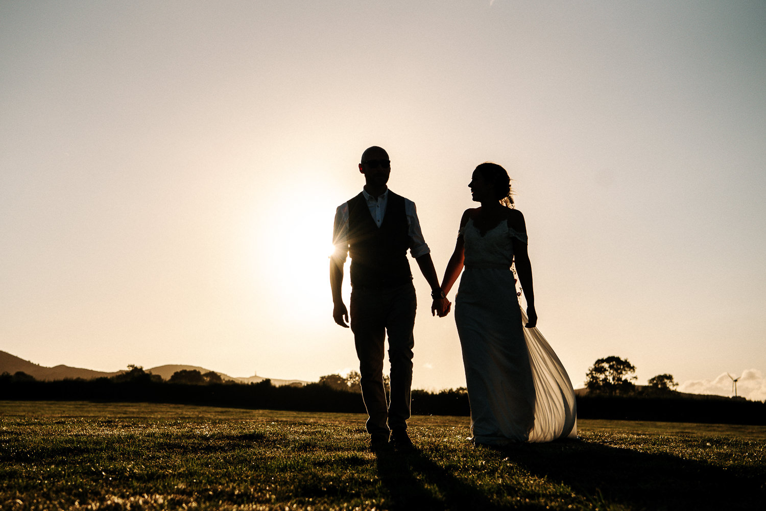 Bride and groom walking in sunset