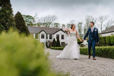the bride and groom walking at the Great Hall at Mains