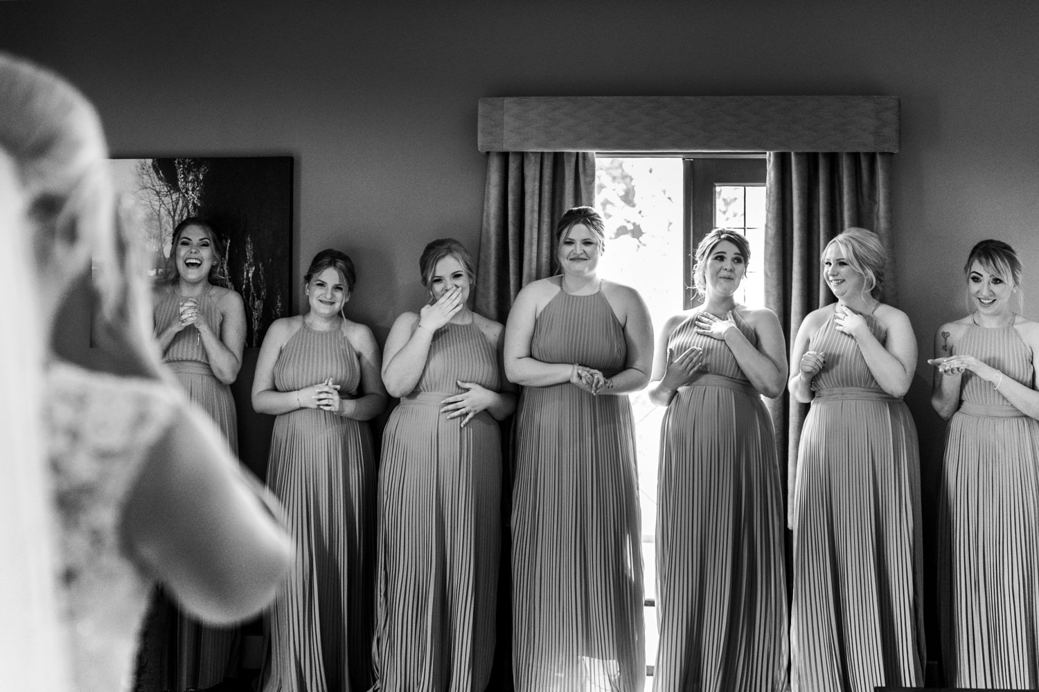 Bridesmaids crying and laughing at seeing the dress