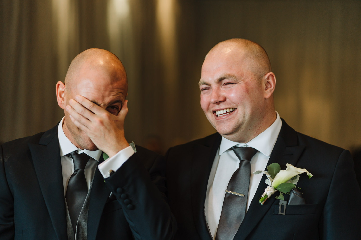 Groom and best man laughing
