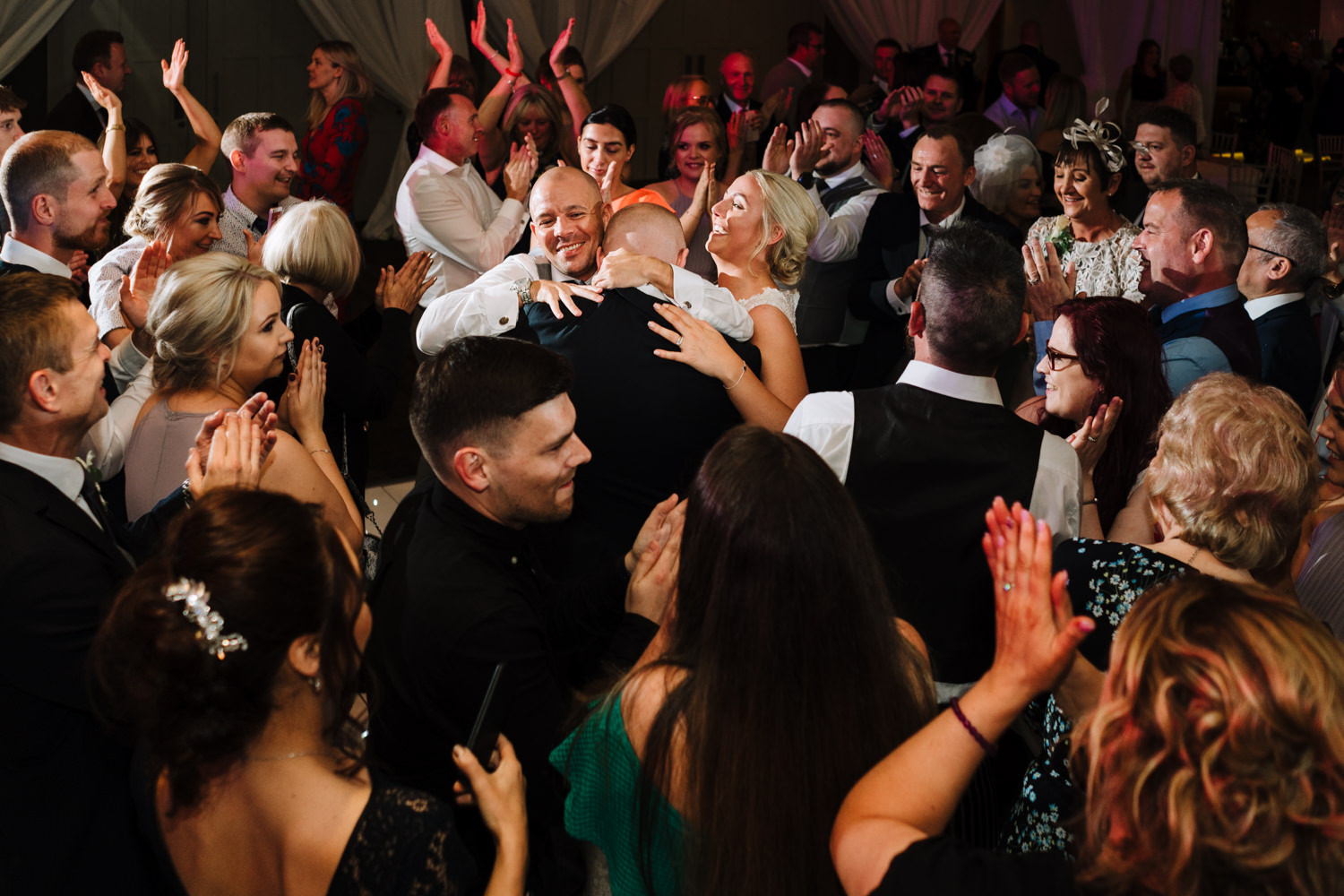 Packed dance floor at the Mere with bride and groom in middle
