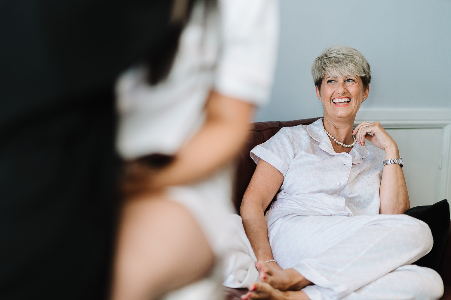 mum of bride laughing whilst bride has her make up
