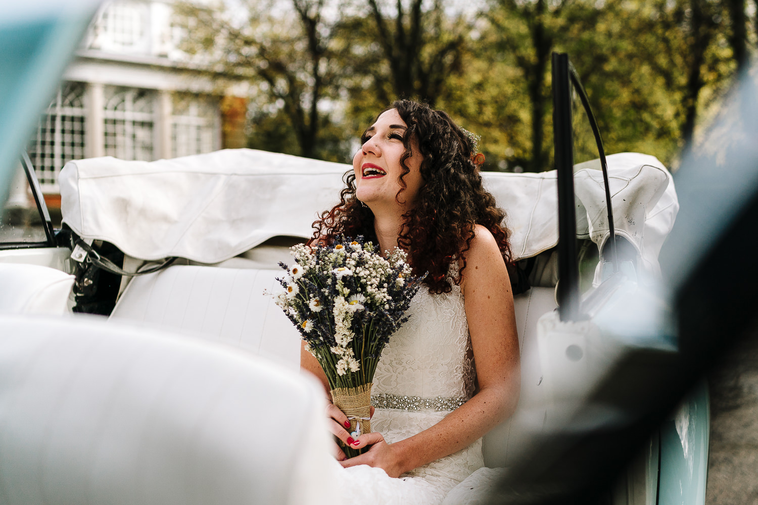 bride smiling in the car before getting married