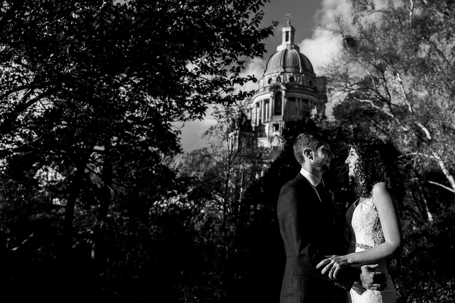 Bride and groom hugging with Ashton Memorial in the background