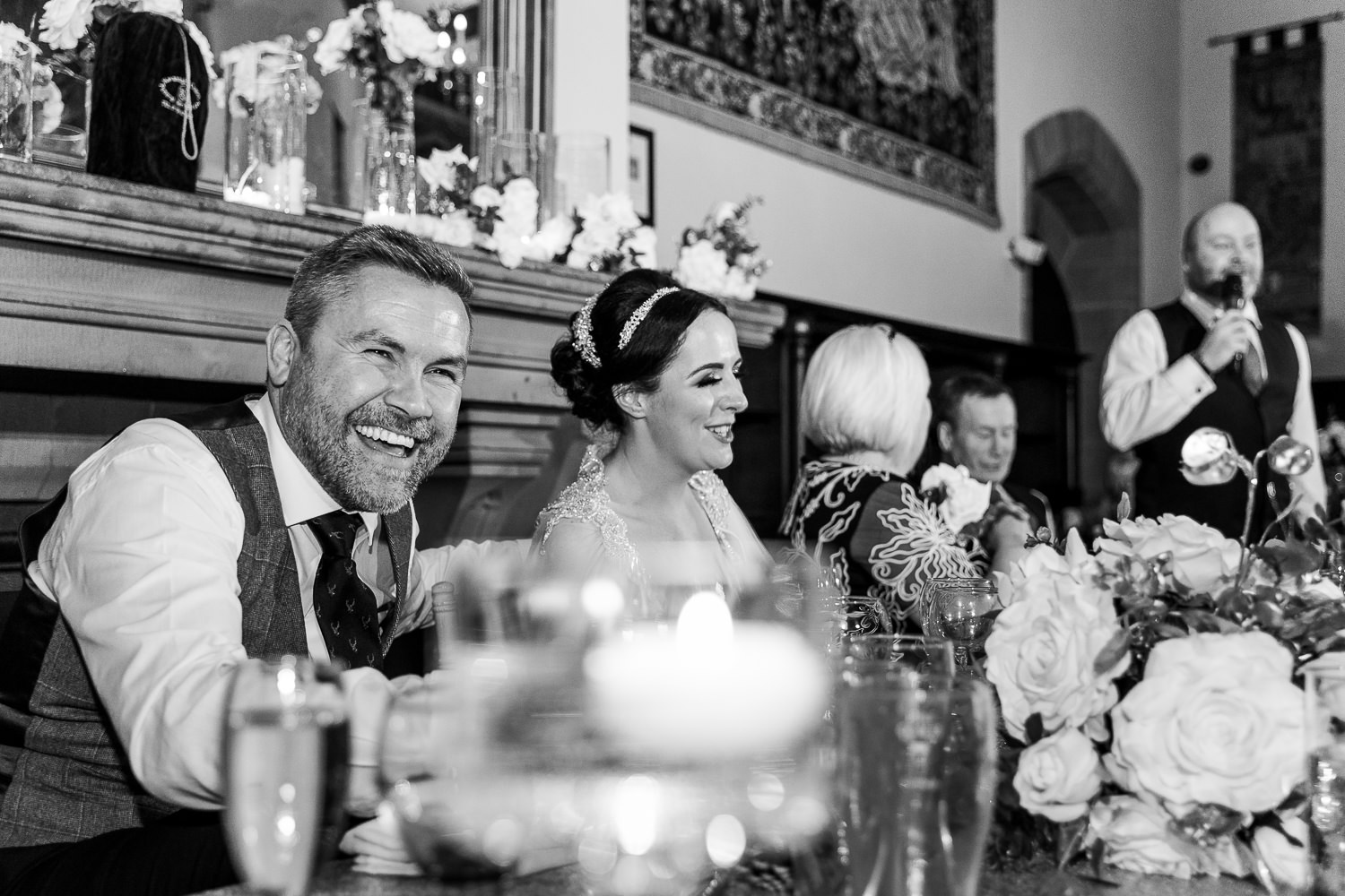 Groom and bride laughing during the speeches at Peckforton Castle's Drawing room