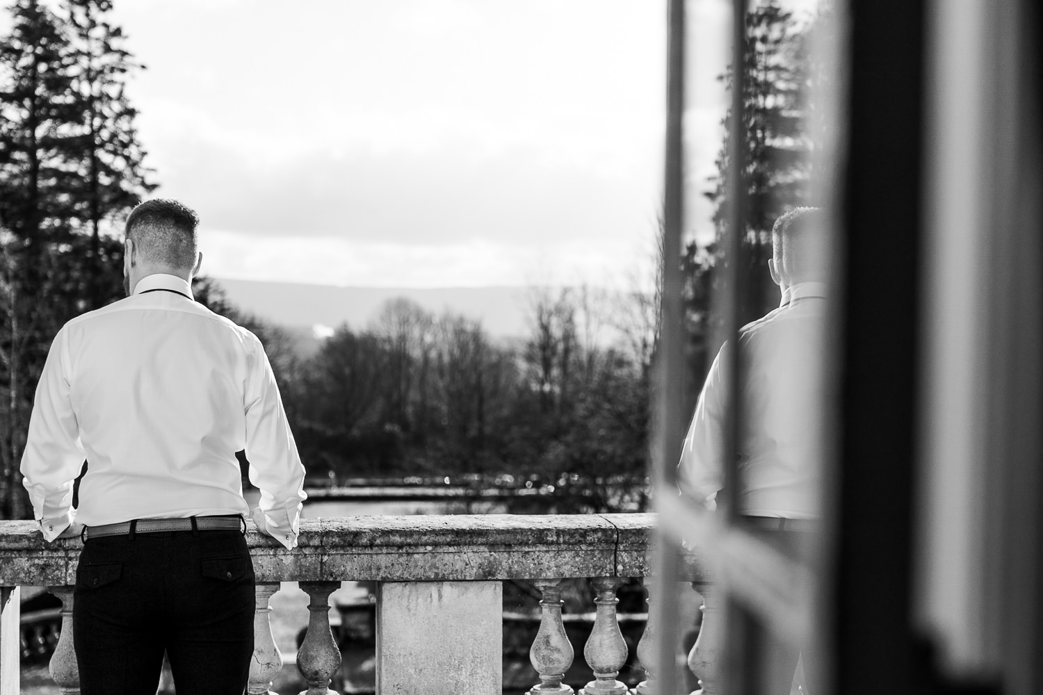 The groom standing on the balcony of Eaves Hall
