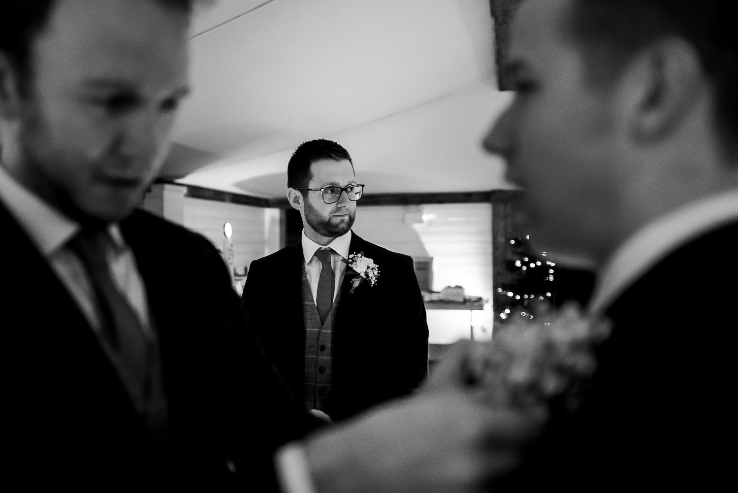 Groom and groomsmen having their button holes put on