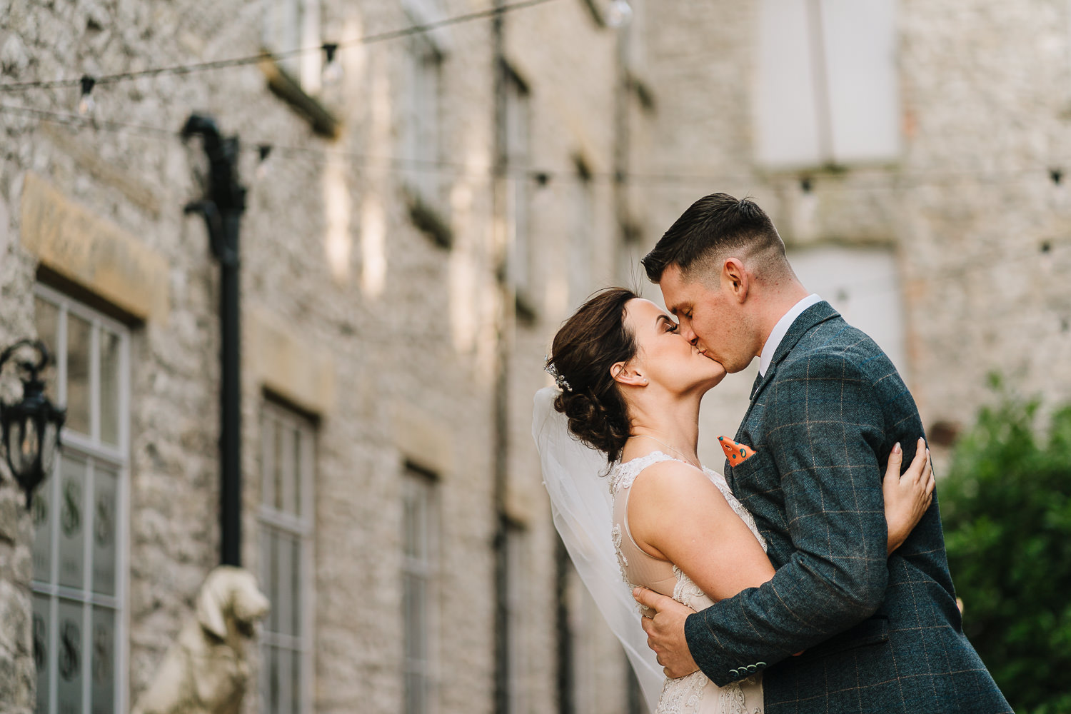 Bride and groom kissing outside Holmes Mill
