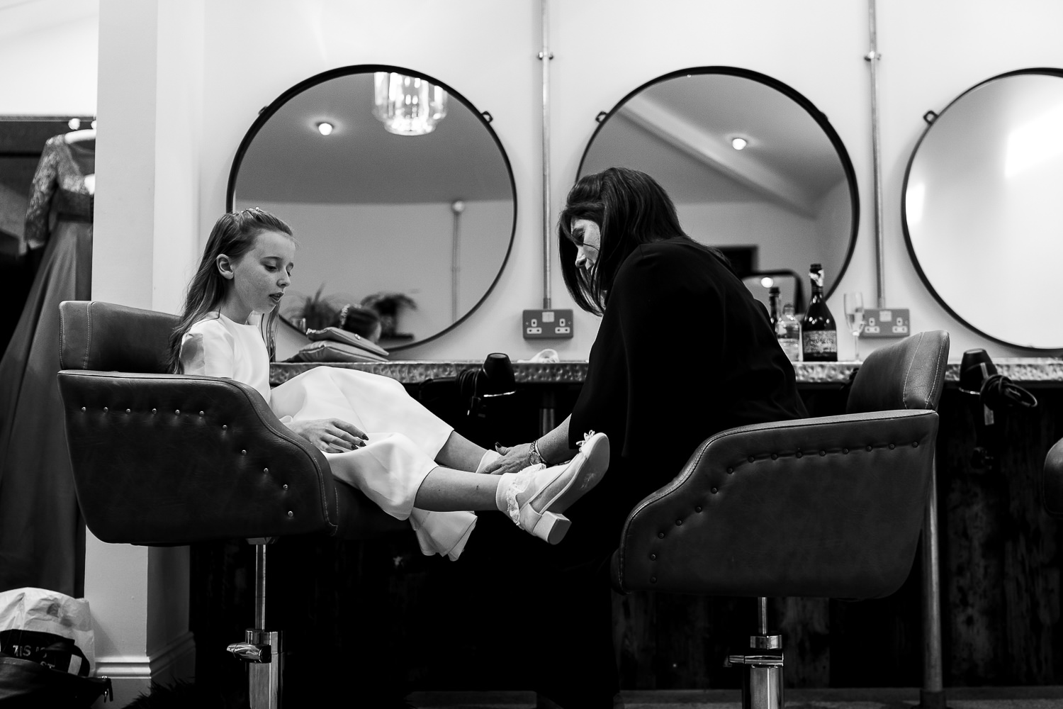 Bride doing up the flower girls shoe
