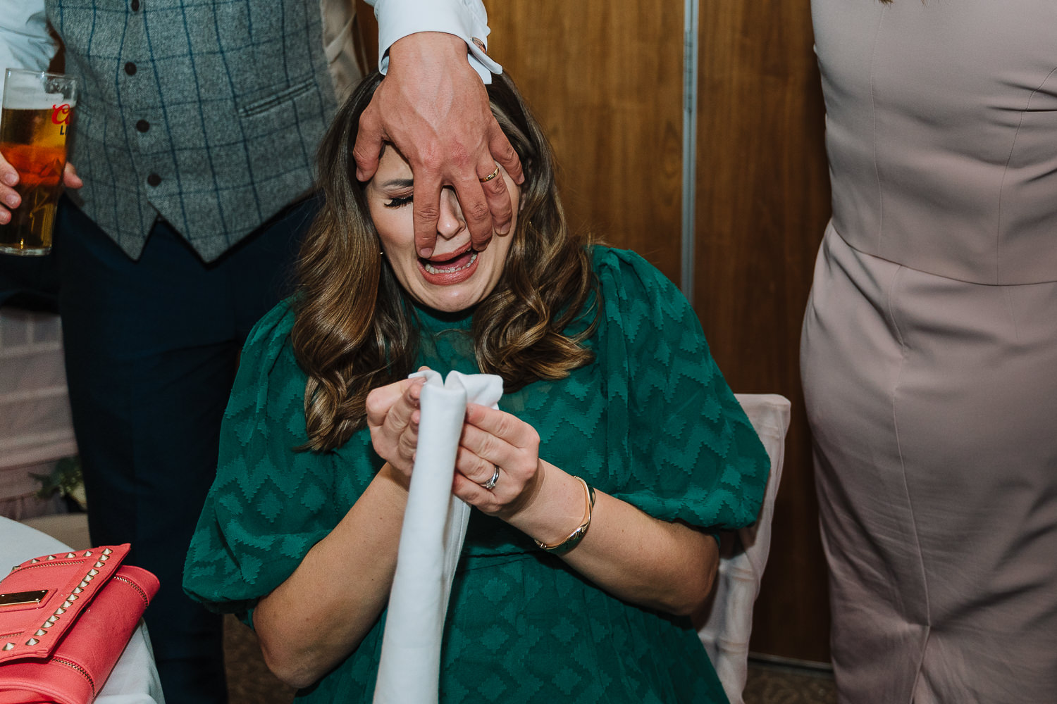 wedding guest having a hand put in her face
