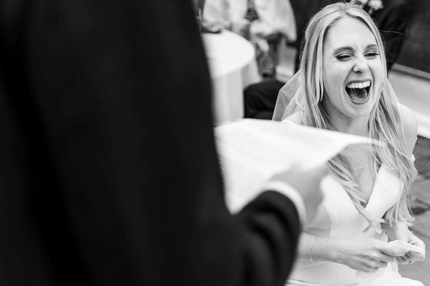 Bride laughing during groom speech