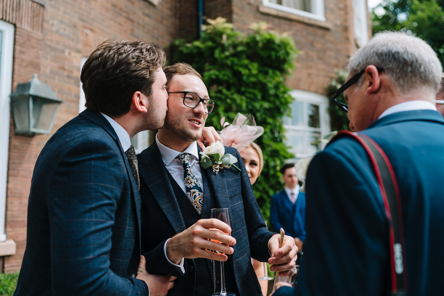 Groom getting kissed of brother