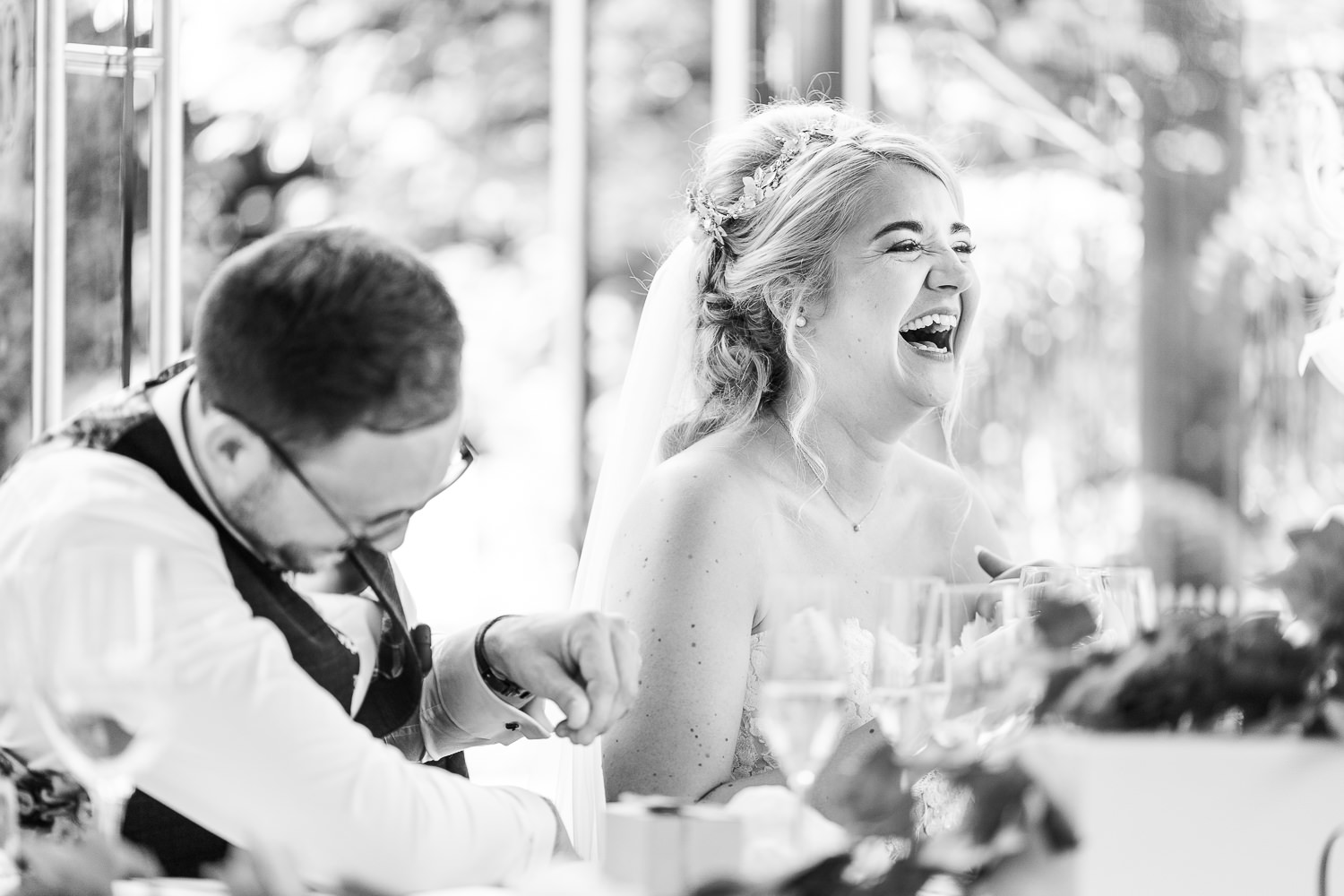 Bride and groom laughing during speeches