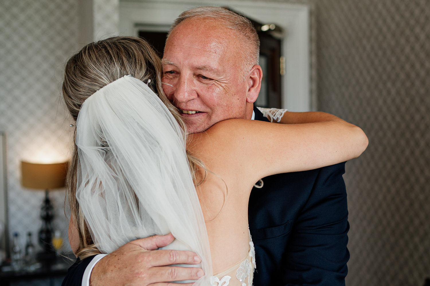 Father of the bride and the bride hugging