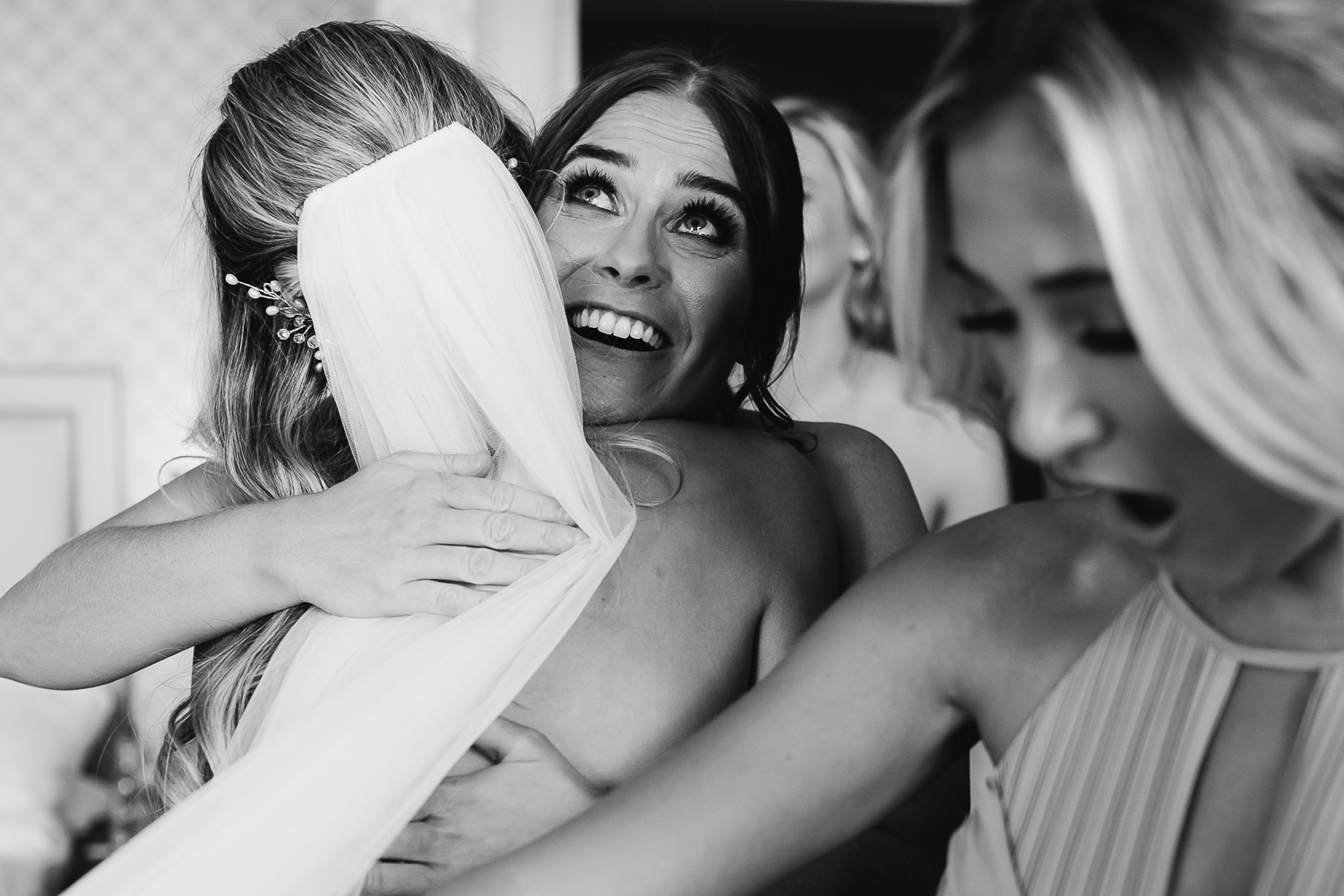 Bridesmaids hugging the bride