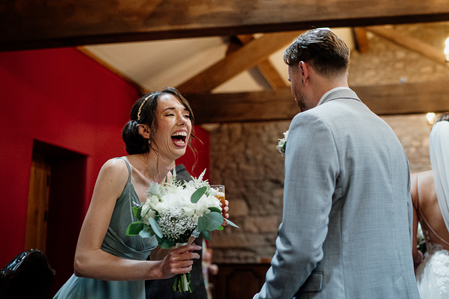 Bridesmaid laughing with groom