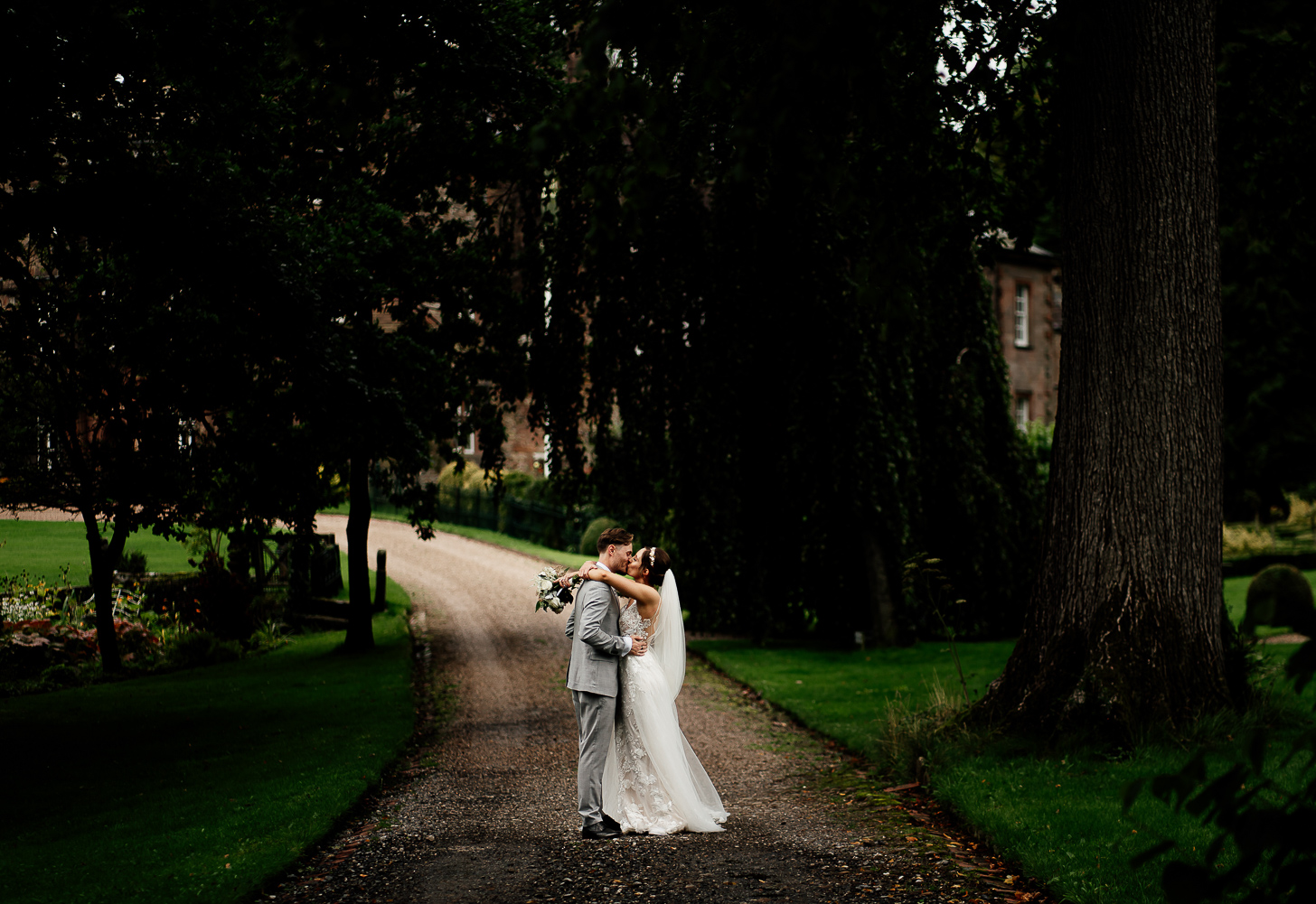 Bride and groom kissing in the grounds of Browsholme