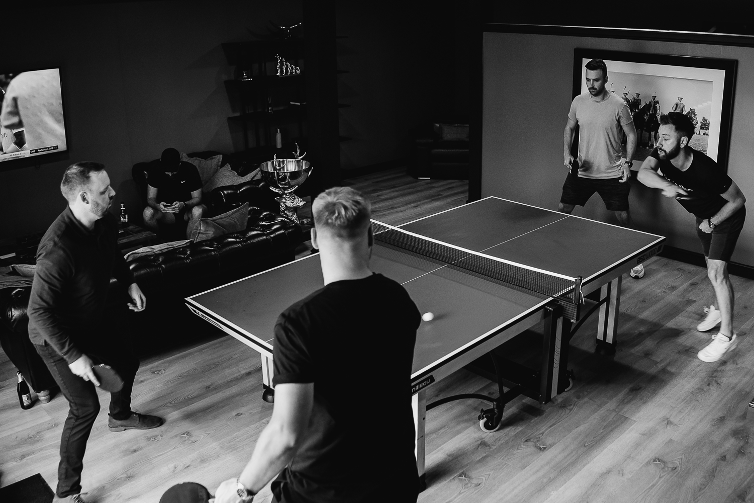 Groomsmen playing table tennis in the den