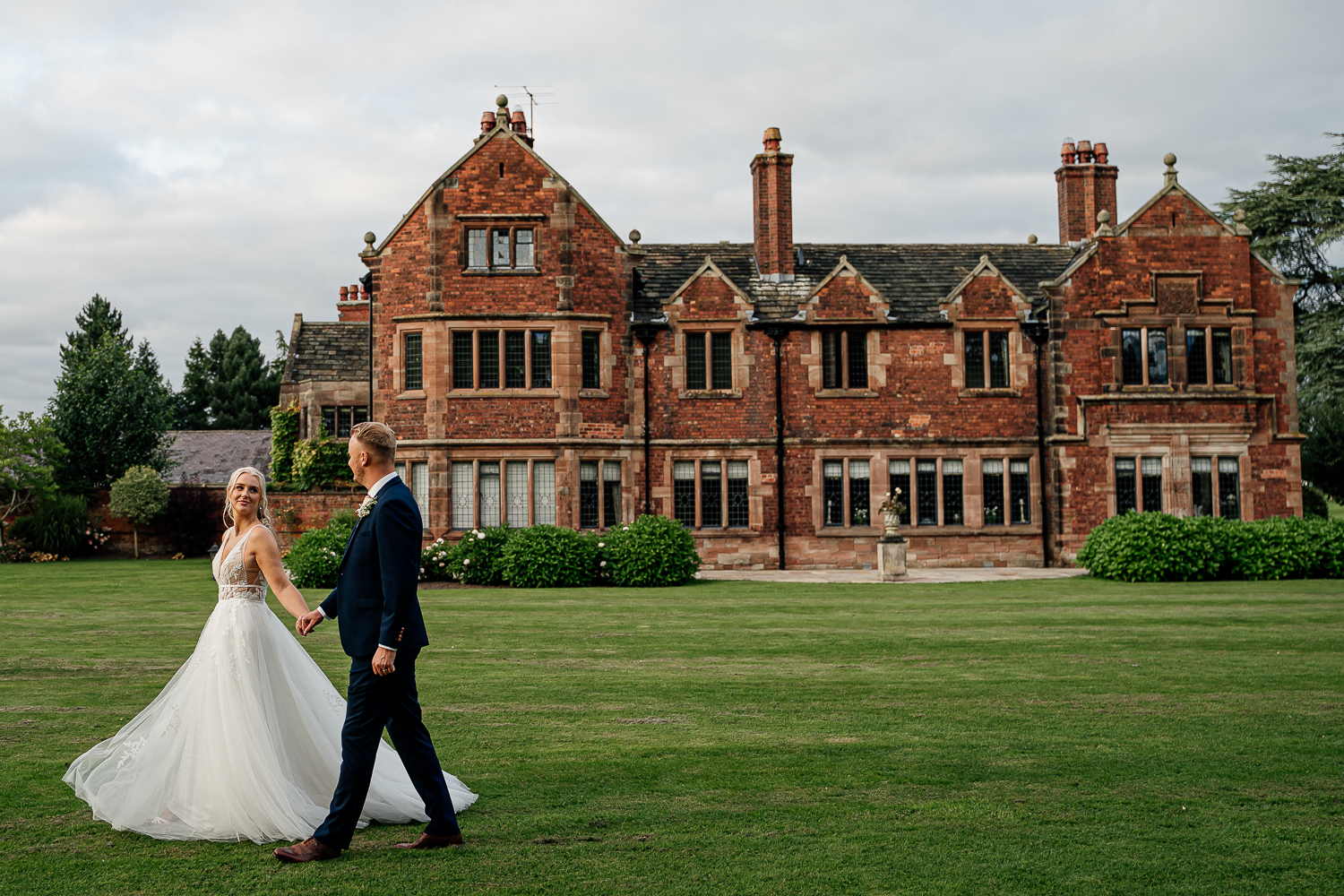 Photo of bride and groom walking at Colshaw Hall