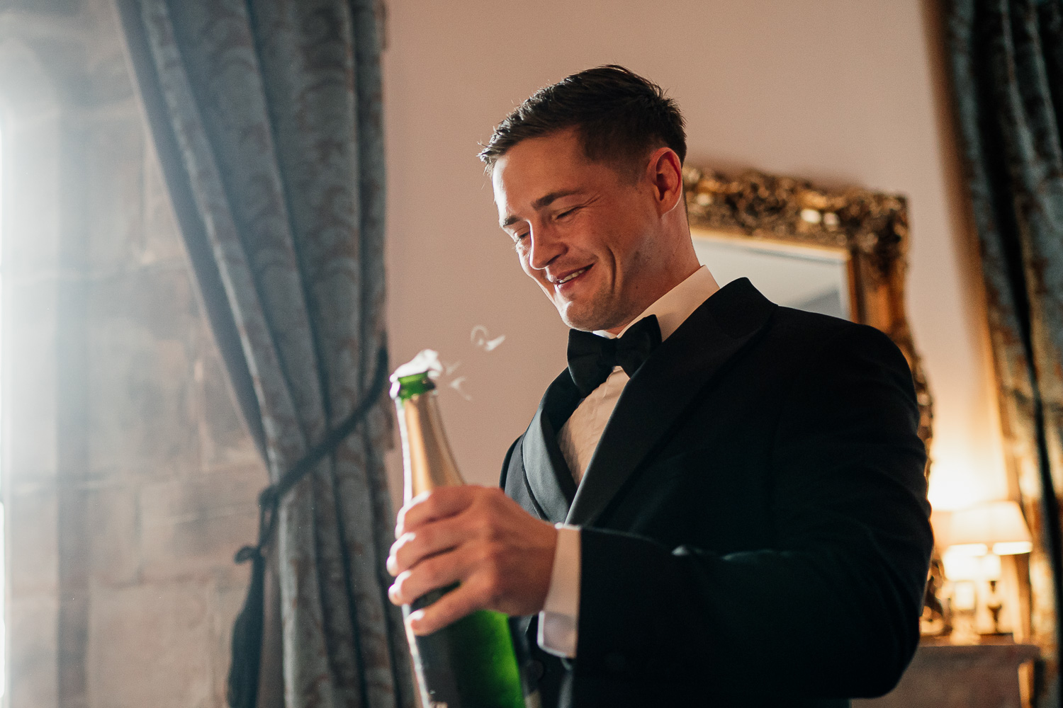 Groom opening up champagne