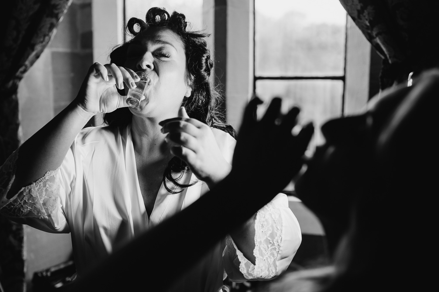 Bride and bridesmaid doing a shot at Peckforton Castle