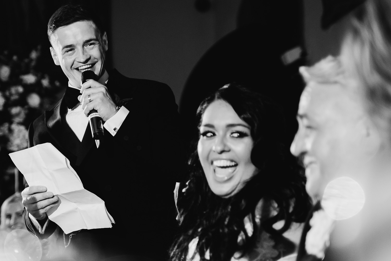 Bride and groom laughing during speeches