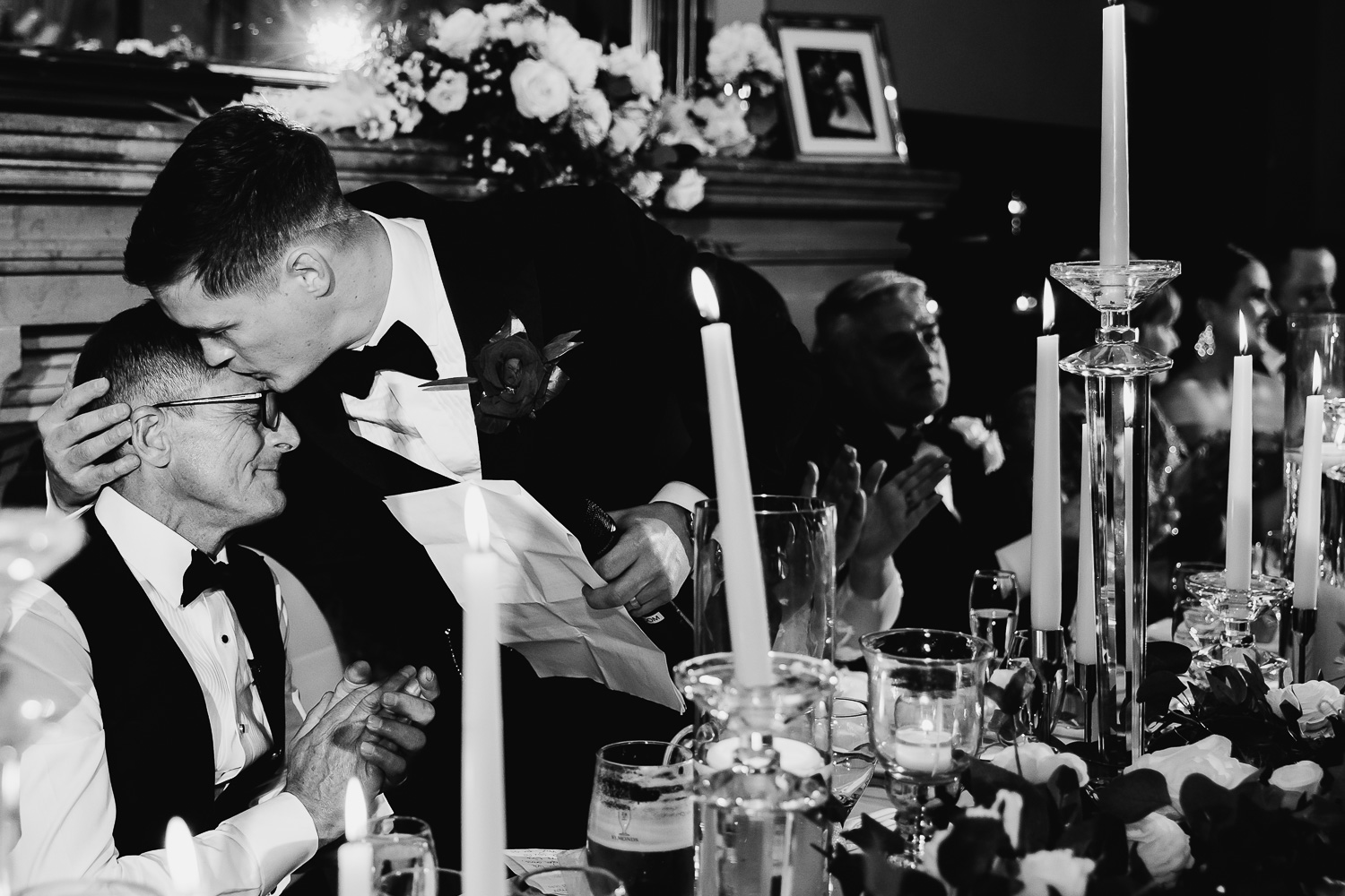 Groom kissing his best man on the head