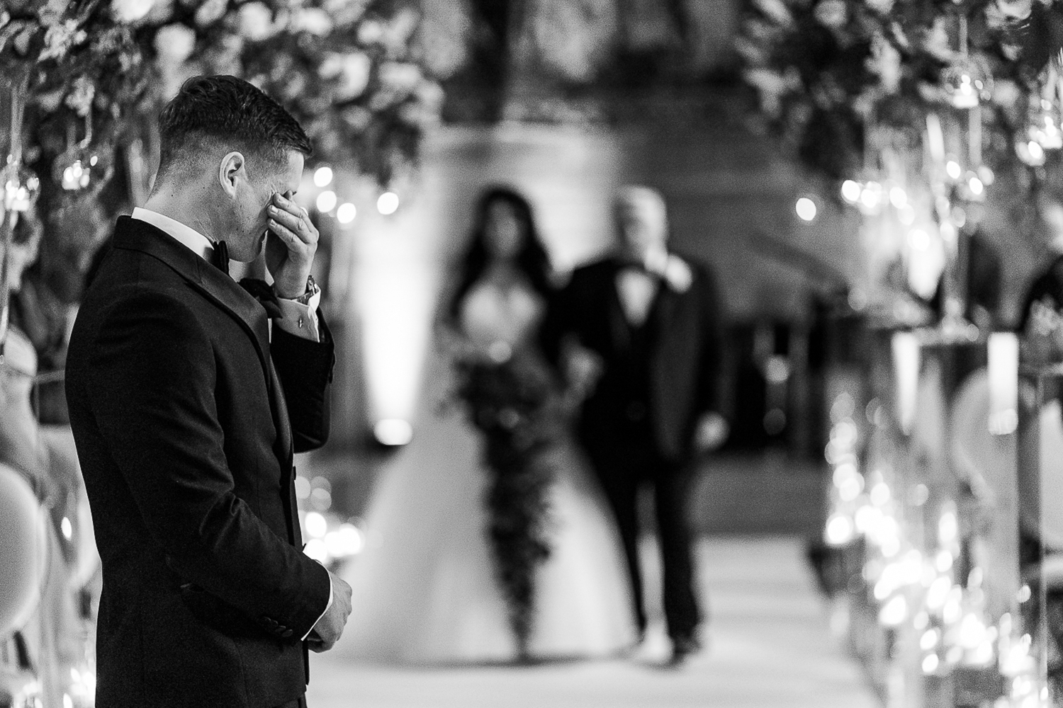 Groom crying as bride walking down aisle