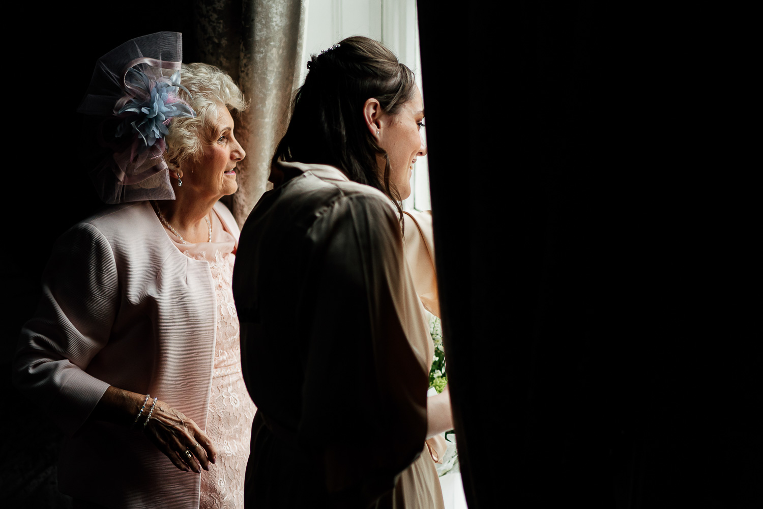 Mother of bride and bridesmaid looking out window